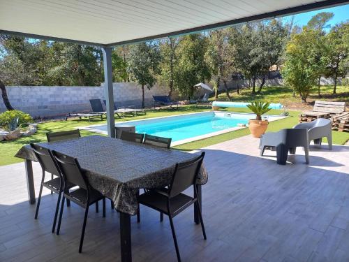 un patio avec une table et des chaises et une piscine dans l'établissement Villa in Rocbaron with Private Pool, à Rocbaron