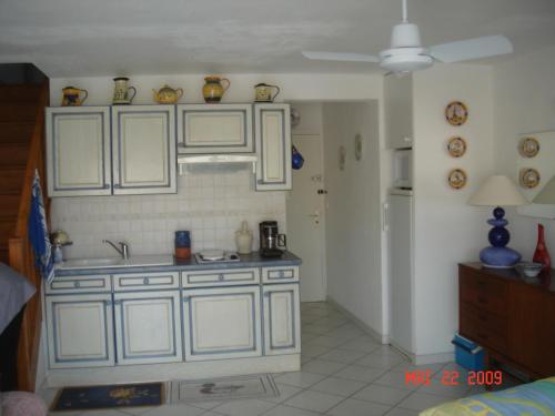 une cuisine avec des armoires blanches et un évier dans l'établissement Plage du mole, sablotel 2, au Cap d'Agde