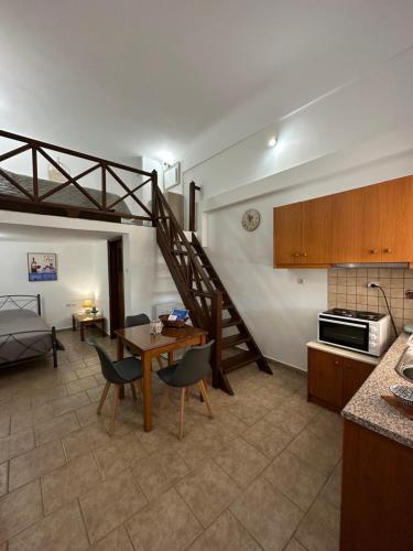 cocina y sala de estar con mesa y escalera en Ano Syros Vibes en Syros