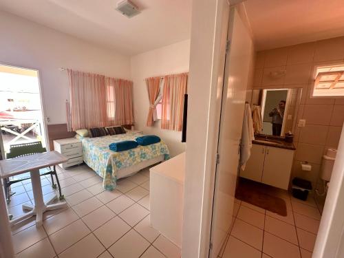 保利斯塔的住宿－Casa Beira Mar Melhor Condomínio，一间卧室配有一张床、一张桌子和一面镜子