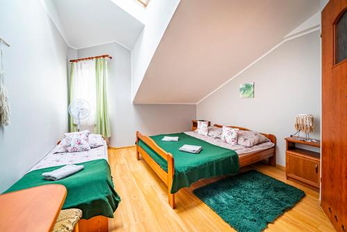 sypialnia z 2 łóżkami i zieloną pościelą w obiekcie Willa Rossa we Władysławowie