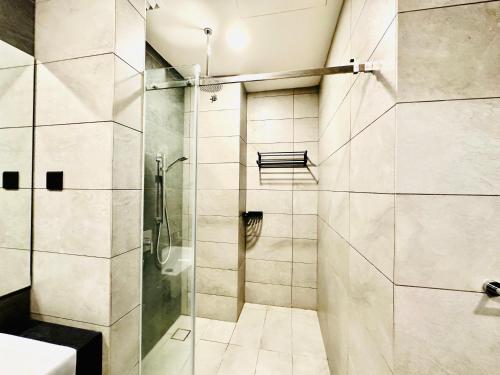 ein Bad mit einer Dusche und einer Glastür in der Unterkunft Millennium Suite At Opus Residence in Kuala Lumpur