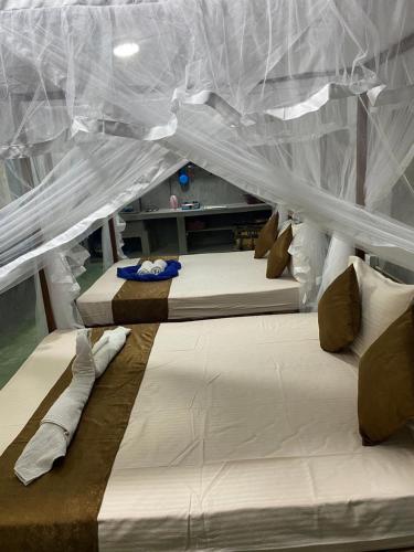 eine Gruppe von 3 Betten in einem Zimmer in der Unterkunft Shek villa in Hikkaduwa