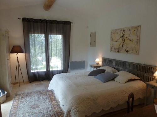 a bedroom with a bed and a large window at Superb air-conditioned house with heated pool in Gordes - by feelluxuryholydays in Gordes