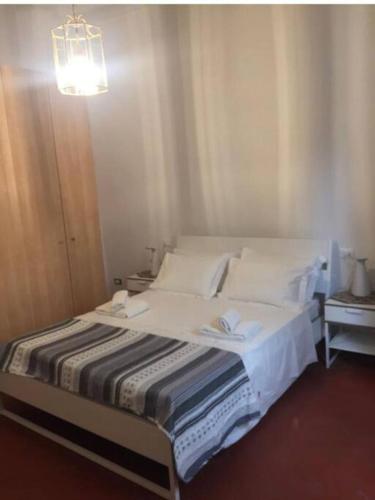 a bed with white sheets and pillows in a room at Living in centro storico in Florence