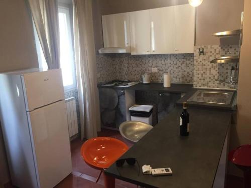 佛羅倫斯的住宿－Living in centro storico，厨房配有黑色柜台和白色冰箱。
