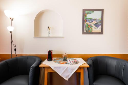 two chairs and a table with a phone on it at PANORAMA SportHOTEL in Wenigzell