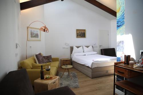 a bedroom with a bed and a couch and a table at Steinacher Hof in Nuremberg