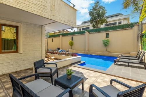 an outdoor patio with chairs and a swimming pool at Baymari Suites Design Florya in Istanbul