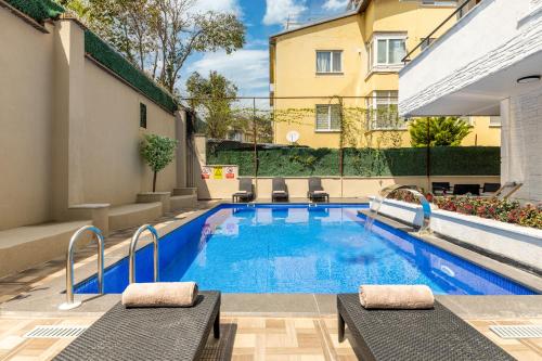 a swimming pool with two chaise lounges next to a building at Baymari Suites Design Florya in Istanbul
