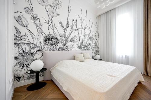 ein Schlafzimmer mit einem weißen Bett und einer Blumentapete in der Unterkunft Vintage Apart on Ekaterininskaya sq. 9 in Odessa