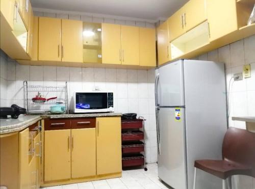een keuken met gele kasten en een koelkast bij Unique location, fully furnished flat in Cairo in Caïro