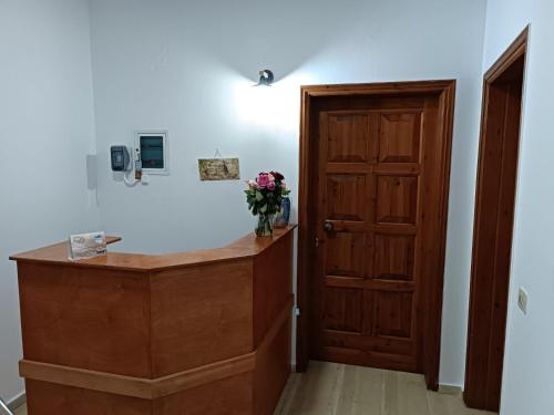 a room with a wooden door and a vase of flowers at Imeros in Chania Town