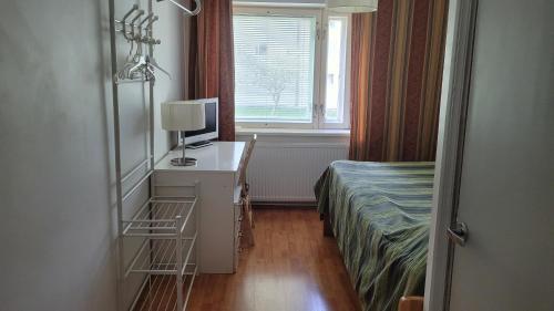 a bedroom with a bed and a desk with a television at Nepi Hotell in Tallinn