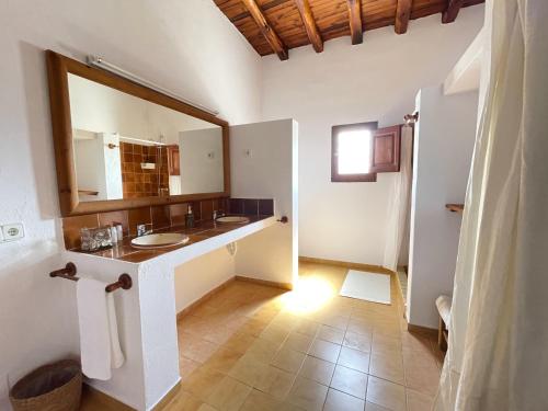 a bathroom with two sinks and a large mirror at Finca Can Toni den Real in Sant Josep de sa Talaia