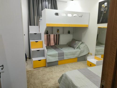 a small bedroom with a bunk bed with yellow cabinets at قريه امواج الساحل الشمالي in El Alamein