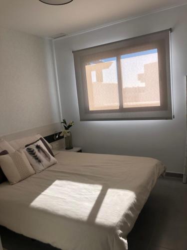 a bedroom with a bed with a window at El Islote de Terreros in San Juan de los Terreros