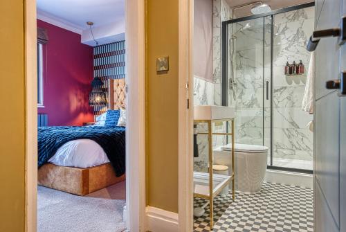 a bedroom with a bed and a walk in shower at Casa Del Artista , Boutique Apartments, Whitby in Whitby