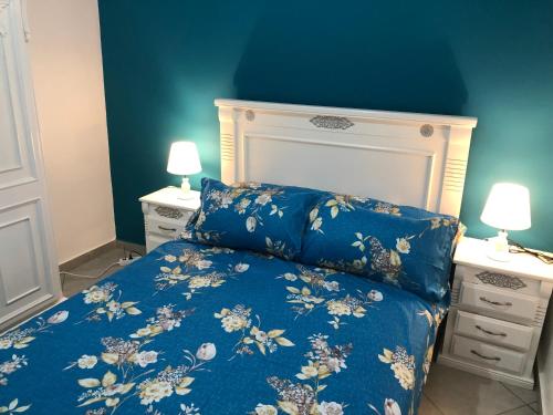ein blaues Schlafzimmer mit einem Bett und zwei Nachttischen in der Unterkunft Superbe Appartement meuble Alliance Darna Tanger in Tangier