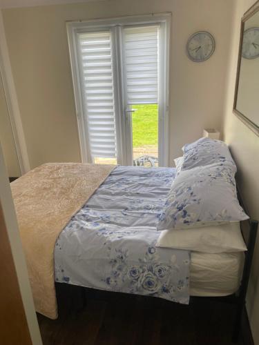 ein Schlafzimmer mit einem Bett mit einer Uhr an der Wand in der Unterkunft K109 Chalet in Camber