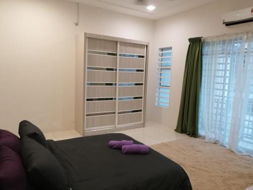 Un dormitorio con una cama con almohadas moradas. en Dudu Guesthouse Kuala Kangsar, en Kuala Kangsar