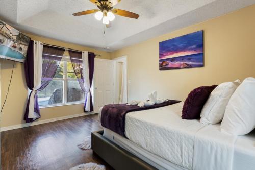 um quarto com uma cama, uma ventoinha de tecto e uma janela em Master Guest Suite with Pool and Private Entrance Minutes to Parks em Orlando