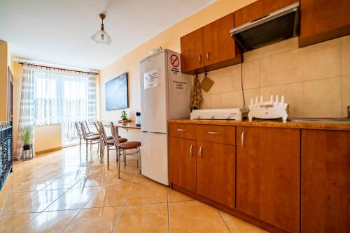 a kitchen with a refrigerator and a table and chairs at Willa Rossa in Władysławowo