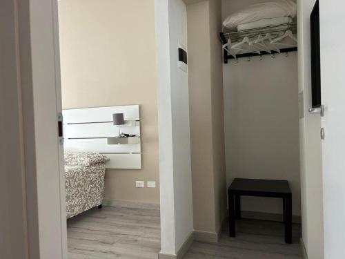 a bedroom with a closet with a bed and a table at ACCADEMIA Rooms in Livorno
