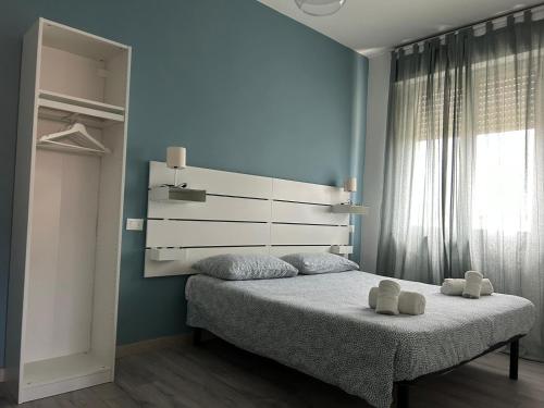 una camera da letto con un letto con due asciugamani bianchi di ACCADEMIA Rooms a Livorno