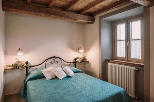 1 dormitorio con 1 cama azul y 2 almohadas en Agriturismo Casa Augusta, en Castiglion Fibocchi