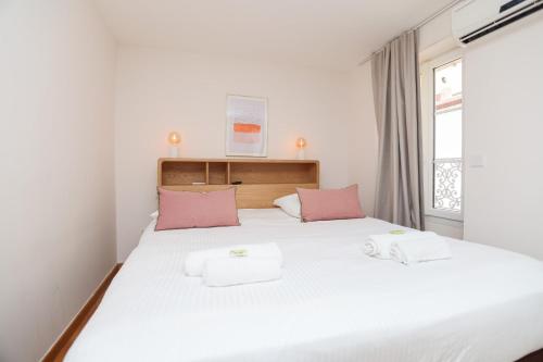 une chambre avec un grand lit blanc avec des oreillers roses dans l'établissement IMMOGROOM - Bright and Cosy - SUQUET - next to the beaches - AC, à Cannes