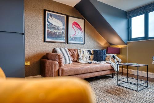 a living room with a couch and paintings on the wall at Casa Del Artista , Boutique Apartments, Whitby in Whitby