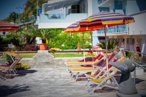 a group of chairs and umbrellas on a patio at Hotel La Mandorla in Ischia