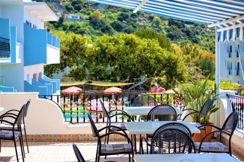a patio with tables and chairs and a view of a pool at Hotel La Mandorla in Ischia