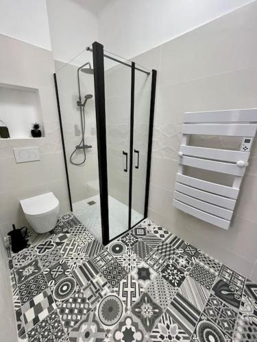 La salle de bains est pourvue de carrelage noir et blanc. dans l'établissement Appartement L’olivier, à Draguignan