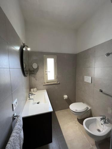 a bathroom with a sink and a toilet at VENTINOVE Apartments in Otranto