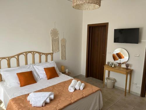 a bedroom with a bed with towels on it at Dirò Camere in Scoglitti