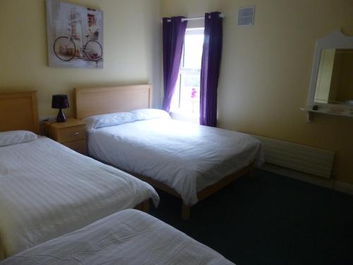 a hotel room with two beds and a window at Walsh's Bridge Inn in Newport