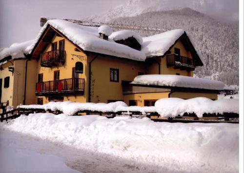una casa coperta di neve di fronte di HOTEL LA GINESTRA a Cesana Torinese