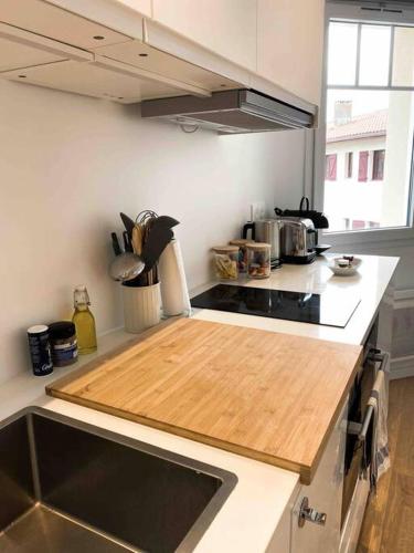 a kitchen with a wooden cutting board on a counter at « Hortense » in Soorts-Hossegor
