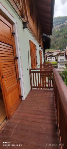 a balcony with wooden doors and a wooden walkway at Casa Hena in Croviana