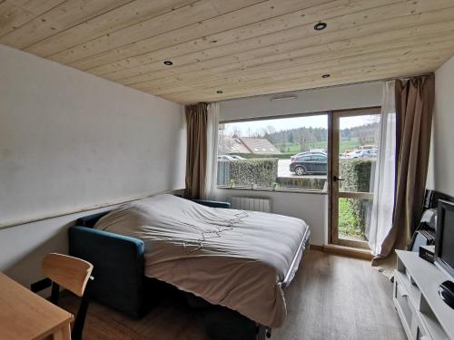 a small bedroom with a bed and a window at L'échappée étoilée - Métabief in Métabief