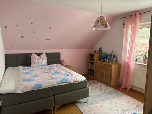 una camera con letto e soffitto rosa di Schöne Ferienwohnung in der Fränkischen Schweiz 