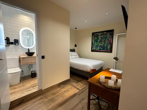 a small bedroom with a bed and a bathroom at PACOROOMS in Madrid