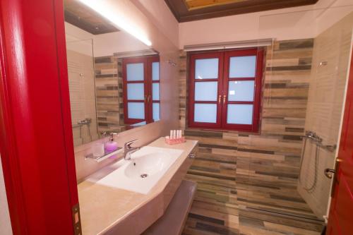 a bathroom with a sink and a mirror at Meliteion Traditional Hotel in Asprangeloi