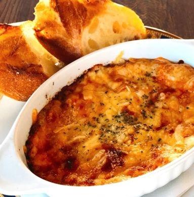 a bowl of food on a plate with some bread at セーナーニカントリーイン in Sammu