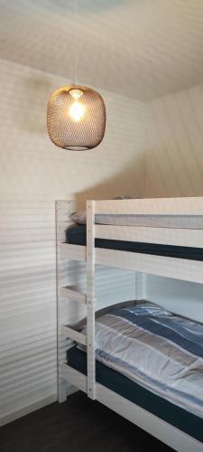 una camera con un letto a castello bianco e luce di Grand appartement 2 chambres avec terrasse a Bordeaux