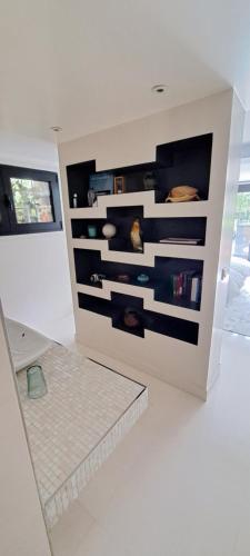 une pièce blanche avec un mur avec une étagère dans l'établissement Havre de paix, à Ville-dʼAvray