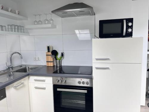 a kitchen with a stove and a microwave at Prime Host apartments in Karlsruhe
