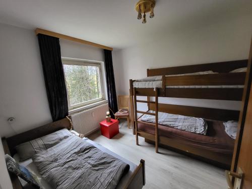 a bedroom with two bunk beds and a window at black-forest holiday - Ferienresort am Schluchsee in Schluchsee